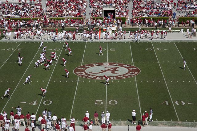 Blick von der Tribüne auf Alabama-Trainingsspiel. Das weiße Team steht an der Line fo Scrimmage, das rote Team in der Verteidigung.