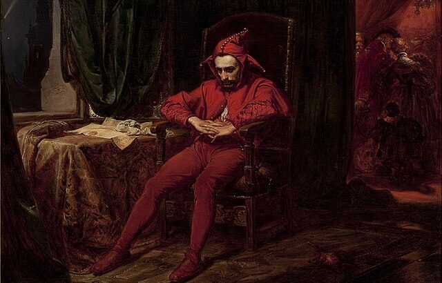 Gemälde. Ein Hofnarr komplett in rot gekleidet, sitzt ermattet mit gefalteten Händen auf einem Stuhl. Der Hintergrund des Zimmers ist dunkel.