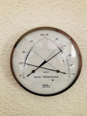 Analoges Thermo/Hygrometer vor Tapete. 18 Grad, etwas über 40% Luftfeuchtigkeit.
