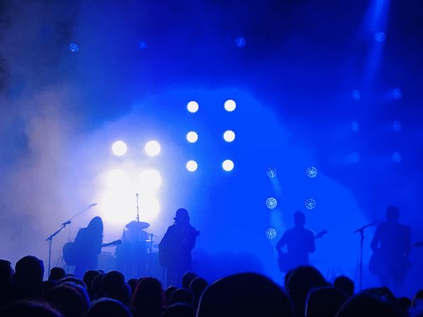 Bühne mit Rockband, Nebelmaschinennebel, blaue Beleuchtung, Musiker in Schemen zu erkennen.,