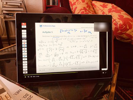 Tablet mit Matheaufgabenfilm. Im Hintergrund Wohnzimmer.