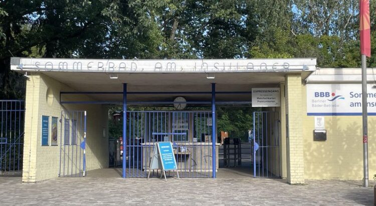 Eingang zum Sommerbad am Insulaner. Ein schmales Kassenhäuschen, unter einem Dach mit zwei Durchgängen links und rechts.