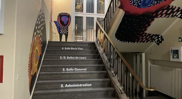 Treppenhaus den Institut français mit französischer Beschriftung, Wandbildern und dem Schild Cinema Paris - Balkon.