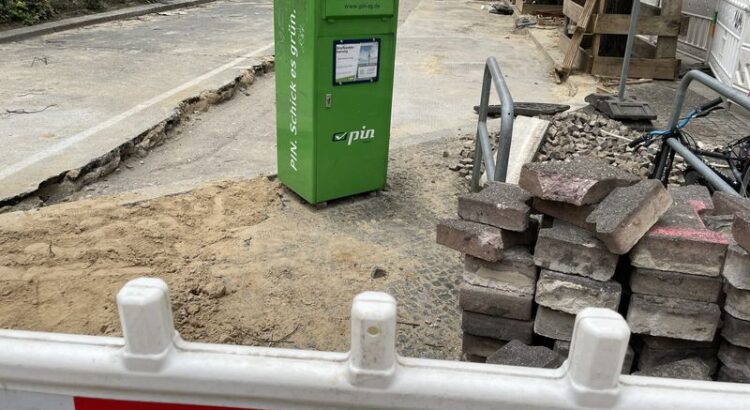 Grüner PIN Briefkasten inmitten einer Baustelle