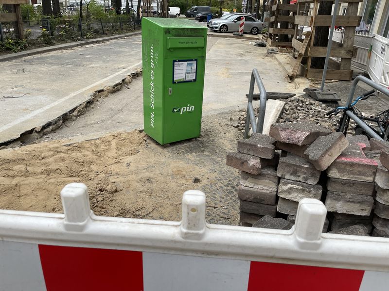 Grüner PIN Briefkasten inmitten einer Baustelle