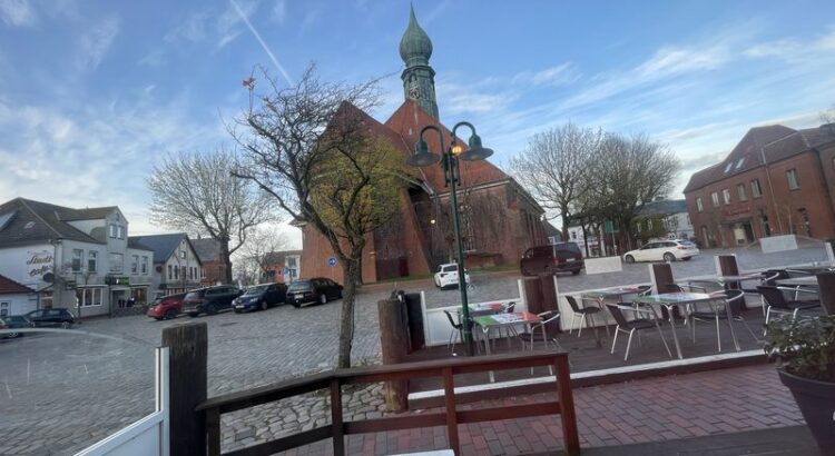 Wesselburen, St. Batholomäus und Marktplatz und Blauer HImmel fotografiert aus dem Eiscafe.