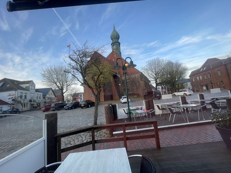 Wesselburen, St. Batholomäus und Marktplatz und Blauer HImmel fotografiert aus dem Eiscafe.