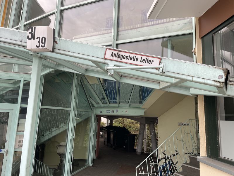 Schild "Anlegestelle Leiter" an einem Großwohngebäude der 1970er/1980er